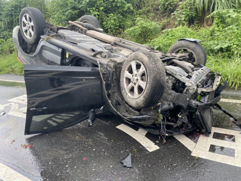 打滑失控｜小轎車自撞中央分隔島路燈桿後翻覆至外側車道，駕駛無恙！