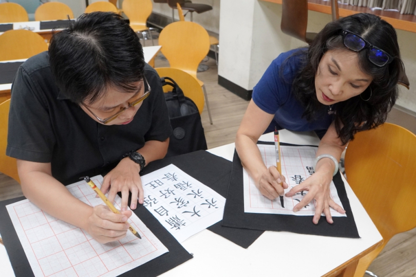 大葉國際學生寫書法,由鄧婉玲教授(右)指導。(照片大葉提供)