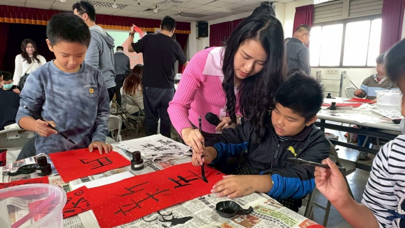彰化磺溪扶青社指導家扶兒寫書法。（照片家扶提供）