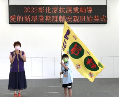 家扶暑期課輔班開課，學童代表揮動家扶旗幟。（照片記者林碧珠攝）