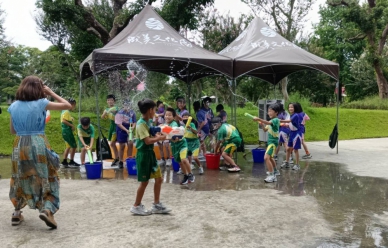 成美文化園「水花大作戰」，大姐姐小嫺（左）被小朋友集中水槍猛攻，招架不住。（記者林碧珠攝）